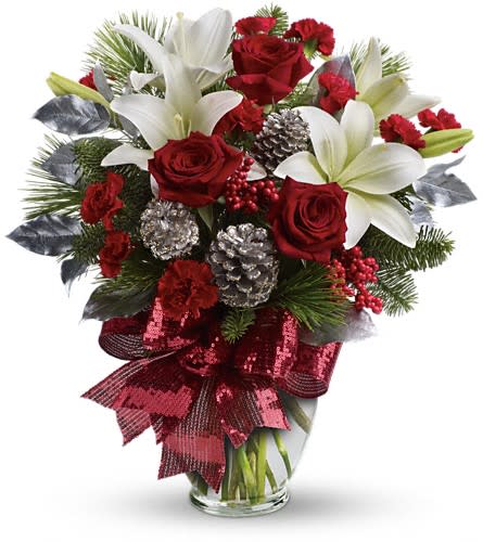 Holiday Enchantment Bouquet - Take your holiday gift-giving to new heights with this dramatic bouquet! Classic red roses snowy lilies and naturally festive berries and pine are gathered in a tall arrangement they'll long remember. A lavish arrangement of red roses white asiatic lilies red carnations noble fir white pine red berries accented with silver pinecones and leaves. Finished with a rich red ribbon this bouquet is dressed in holiday style.Approximately 17&quot; W x 19&quot; H Orientation: One-Sided As Shown : TWR07-1ADeluxe : TWR07-1BPremium : TWR07-1C