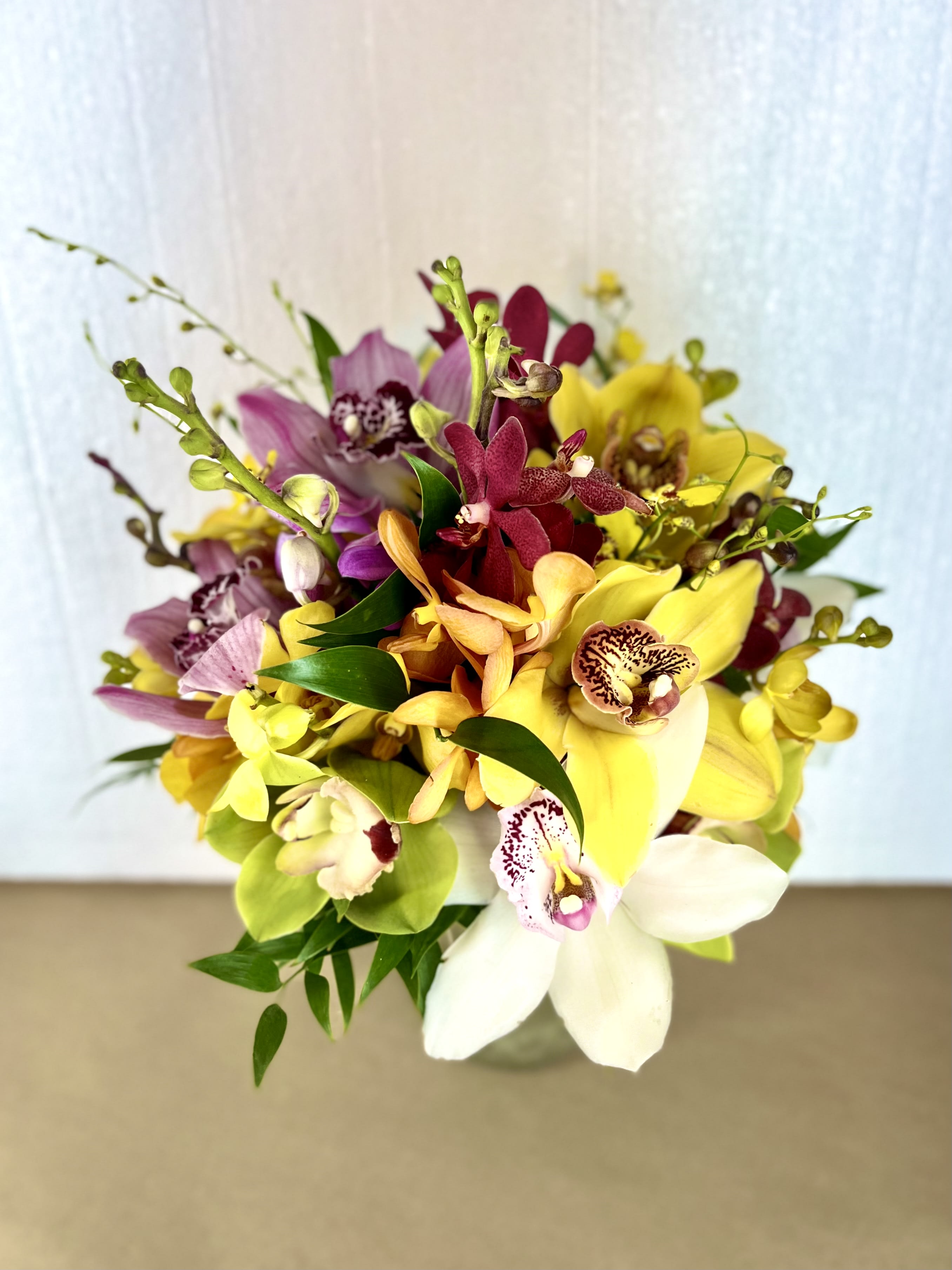 TROPICAL ORCHID BOUQUET  - 7&quot; - 8&quot; Beautiful Hand-held bridal bouquet made with cymbidium and makara orchids and ruscus greens.  *** Please list up to 3 colors in the &quot;Special Instructions&quot; section upon checking out. 