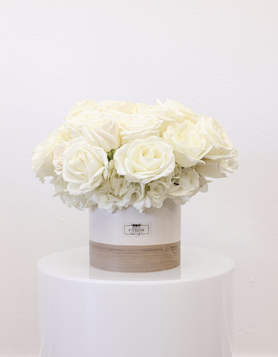 Alban  - Bring beauty to the table with elegant arrangement, presented in a round vase. This arrangement features roses and hydrengea.   Due to the seasonality of flowers or supply chain issues, substitutions may occasionally need to be made. While we understand this is an inconvenience, we will fill your order with an arrangement of similar color and design style.