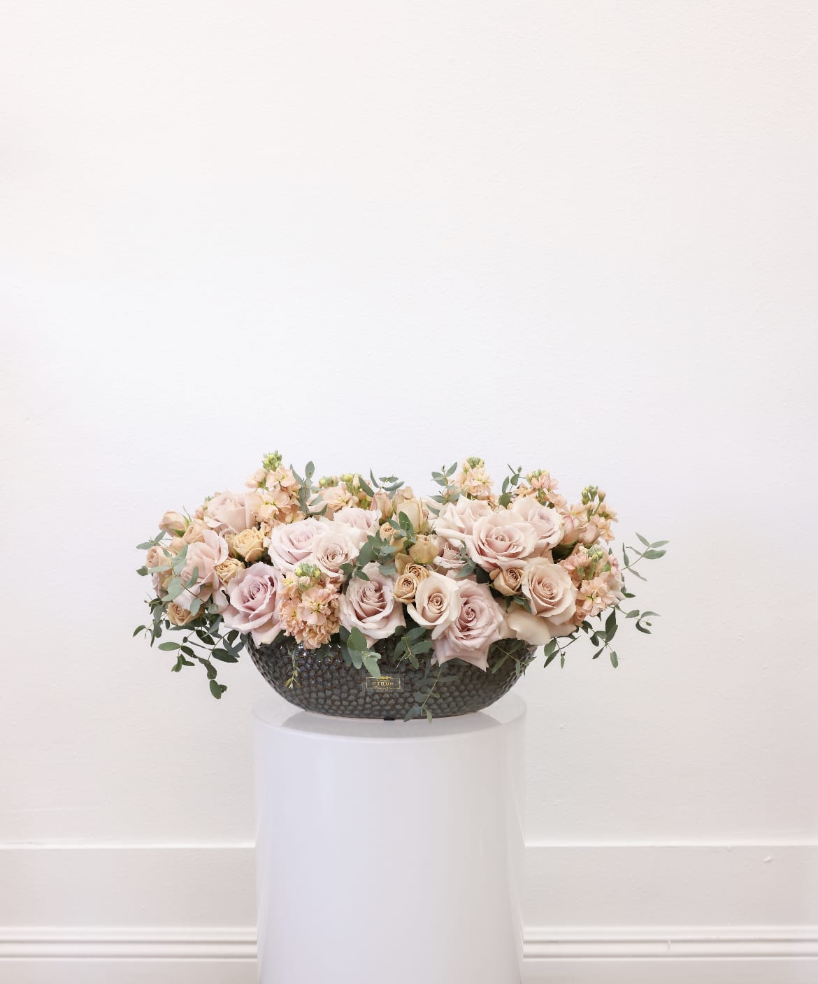 Rkive  - Bring beauty to the table with elegant arrangement, presented in a long vase. This arrangement features roses, stock, spray roses, and greenery.   Due to the seasonality of flowers or supply chain issues, substitutions may occasionally need to be made. While we understand this is an inconvenience, we will fill your order with an arrangement of similar color and design style.