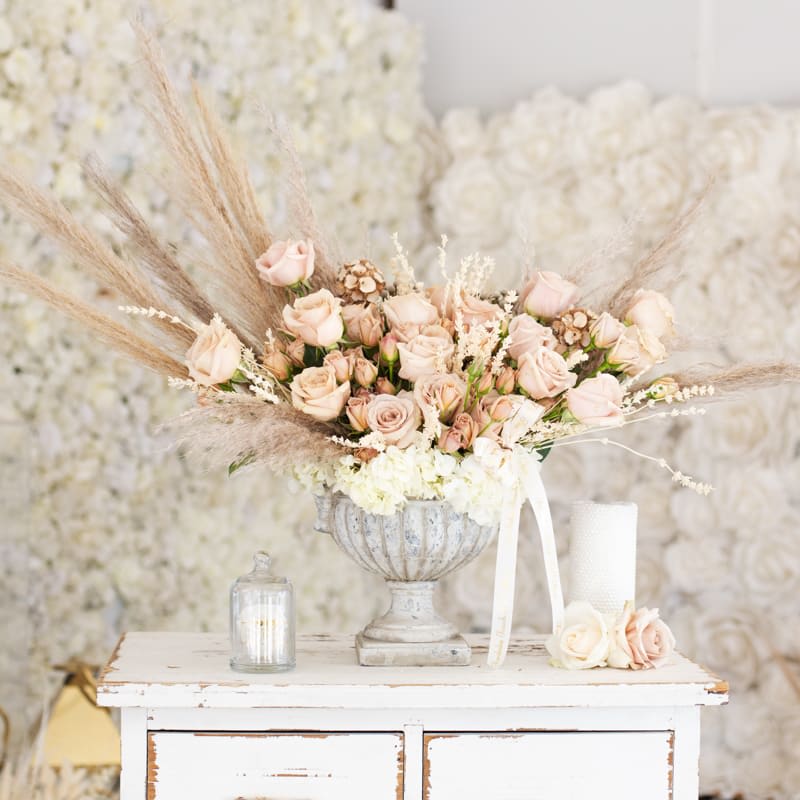 Bare - Bring beauty to the table with elegant arrangement, presented in a championship cement shaped vase. This arrangement features roses, spray roses, hydrangea and preserved florals.   Due to the seasonality of flowers or supply chain issues, substitutions may occasionally need to be made. While we understand this is an inconvenience, we will fill your order with an arrangement of similar color and design style.