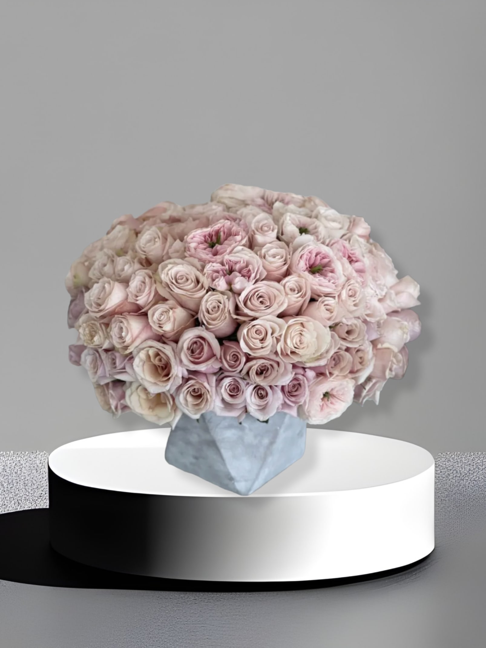 Khloe Blush  - Bring beauty to the table with elegant arrangement, presented in a cement vase. This arrangement features rosesall around.   Due to the seasonality of flowers or supply chain issues, substitutions may occasionally need to be made. While we understand this is an inconvenience, we will fill your order with an arrangement of similar color and design style.