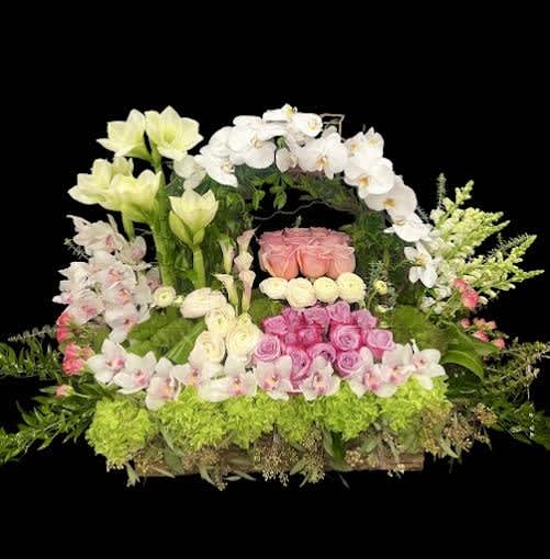 Low exotic beautiful centerpiece Low exotic beautiful centerpiece - Nice and beautiful low centerpiece with a mix of white amaryllis lillies, white phaelonopsis orchids, pink cymbidium orchids, mini calla lillies, mix of spray roses, white snapdragons, orange spray roses, exotic greenery seeded eucalyptus and an abundance of fillers and foliage, expertly designed.