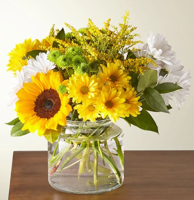 Hello Sunshine Bouquet - Give a dose of sunshine in bloom. This stunning bouquet is teeming with rays of sunflowers, textured snapdragons and darling daisy poms to deliver the perfect pick–me–up for an occasion or as a treat to yourself.  Please Note: The bouquet pictured reflects our original design for this product. While we always try to follow the color palette, we may replace stems to deliver the freshest bouquet possible, and we may sometimes need to use a different vase.