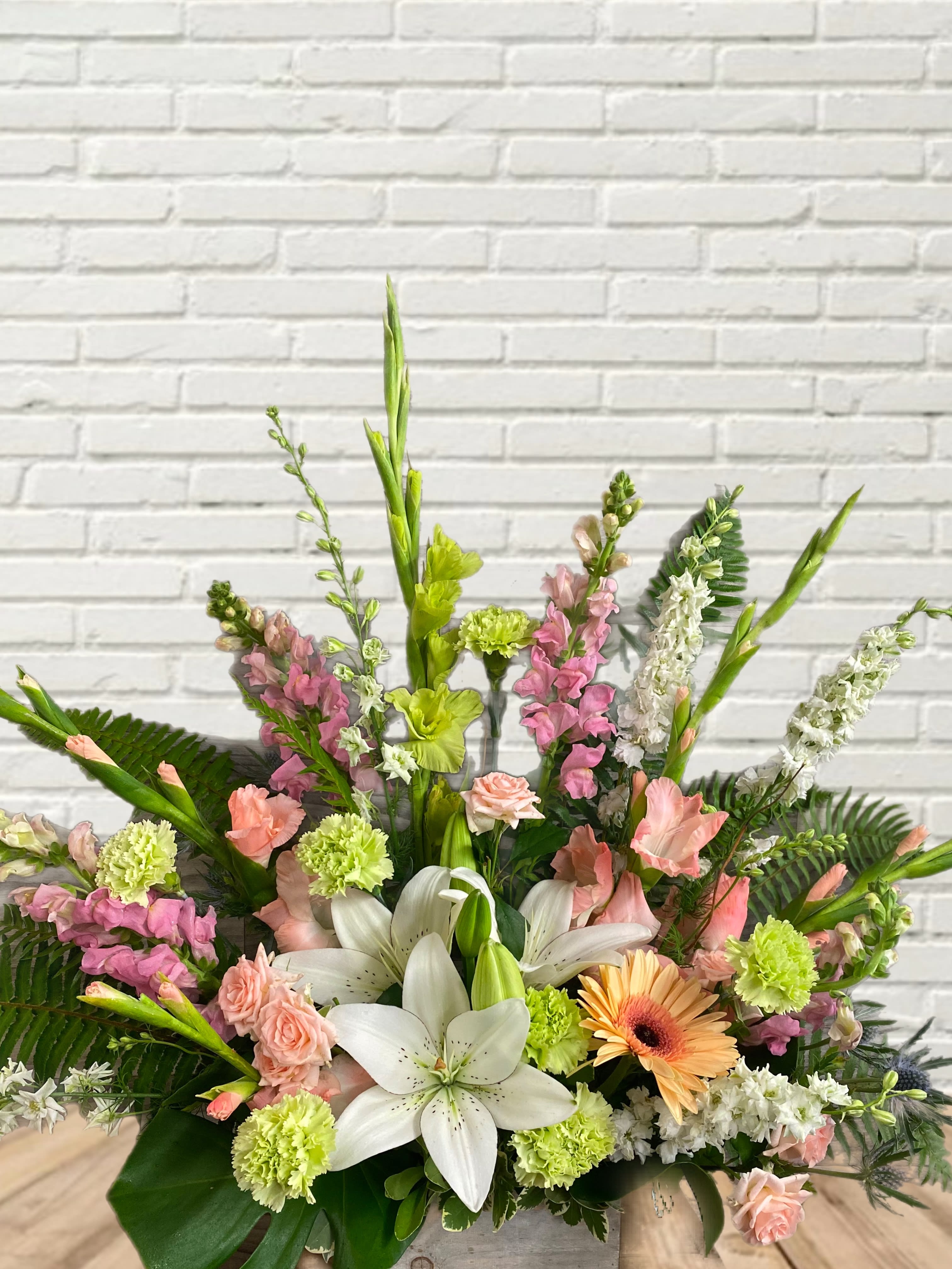 Sweetly Sherbert Sweetly Sherbert - A subtly sweet bouquet with lilies, carnations, spray roses, gladiolus, snapdragons, and larkspur in wood box pot.