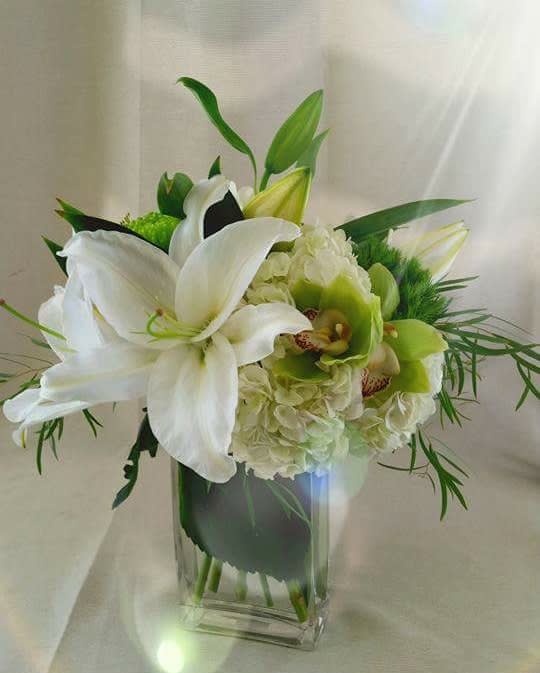Simple Elegance - Casablanca lily arranged with orchids nestled in a hydrangea.