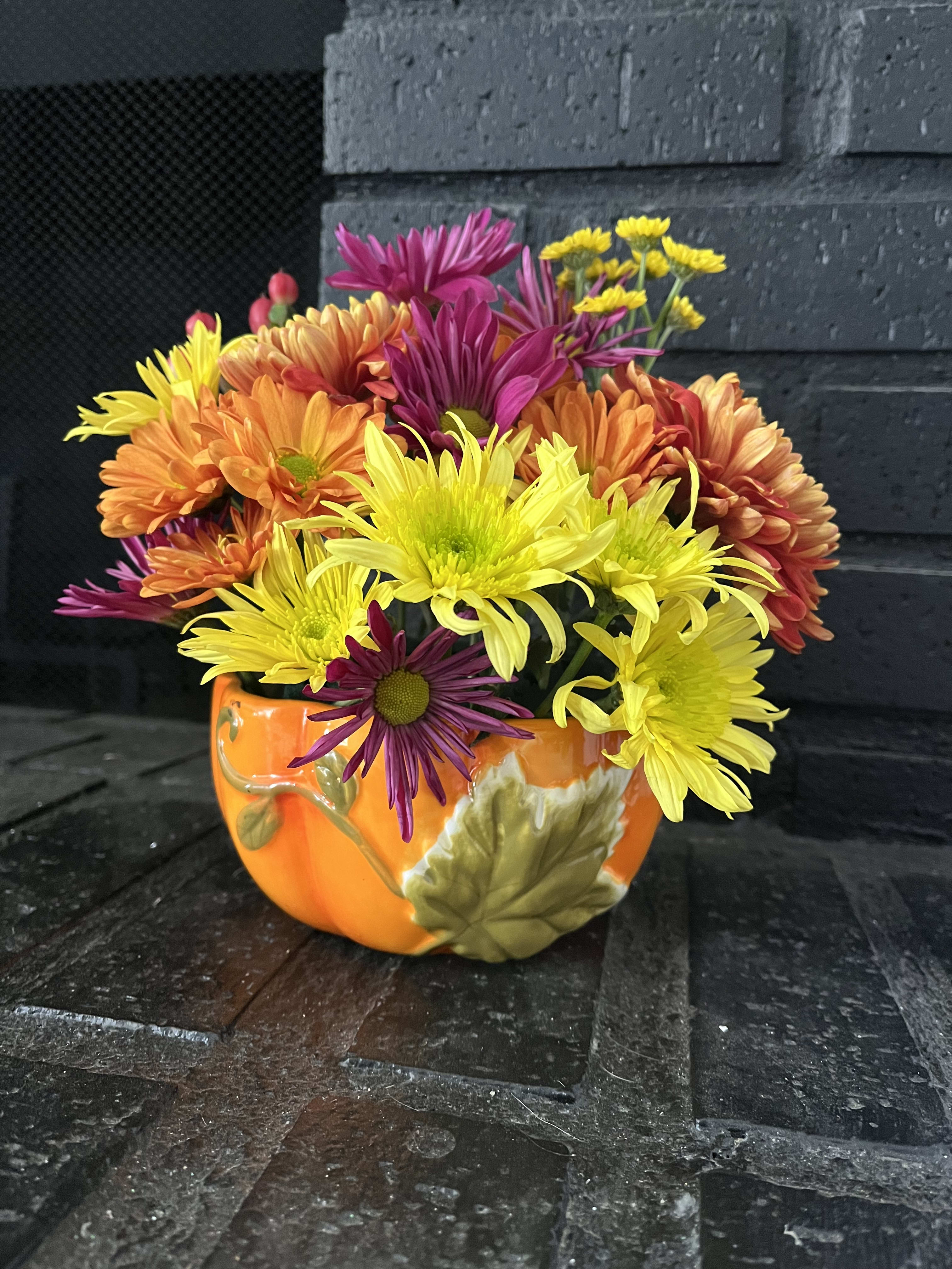 Rosana - Floral arrangement of colors and seasonal flowers in a ceramic container in the shape of a pumpkin, ideal to give this October and on any occasion. Send smiles to your loved ones