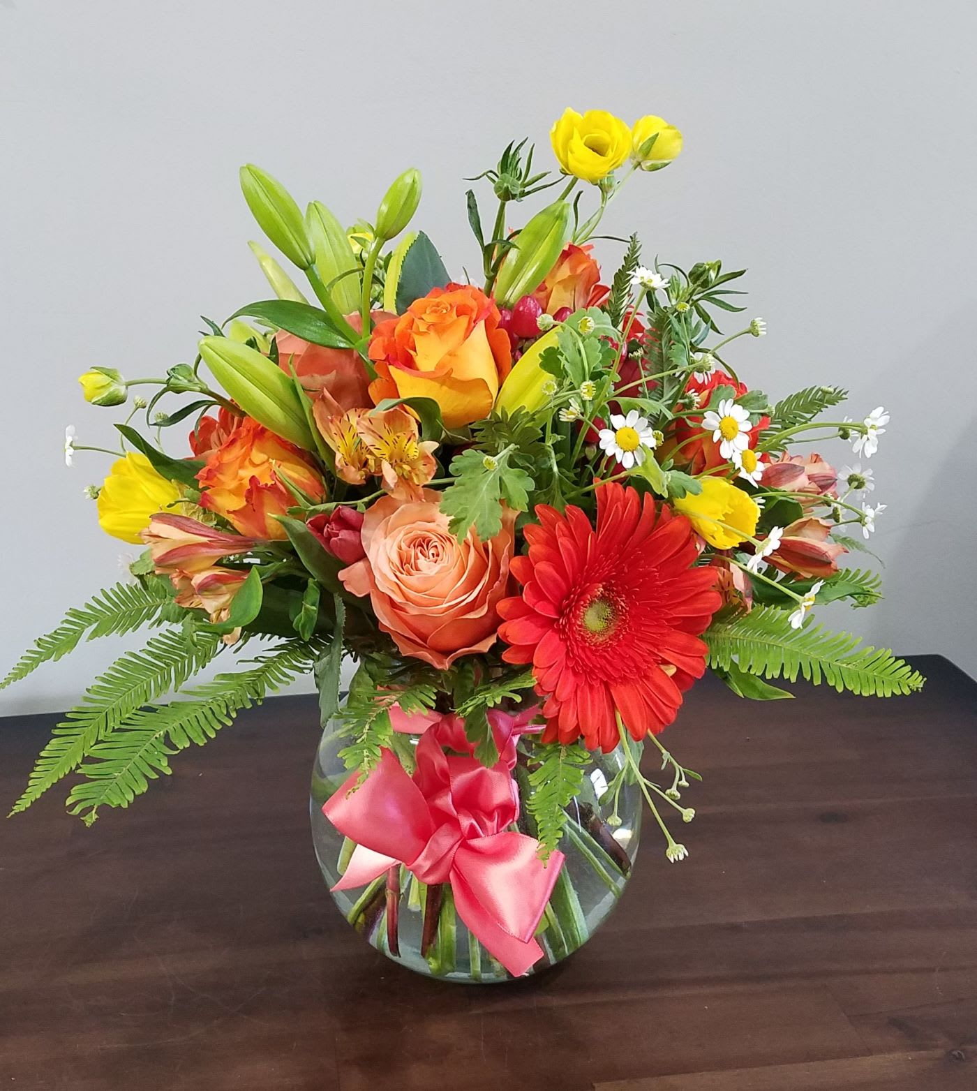 Orange You Grand  - Bright summer blossoms, roses, Gerbera Daisy, Feverfew, Alstroemeria, and Ranunculus will bring a smile to anyone.