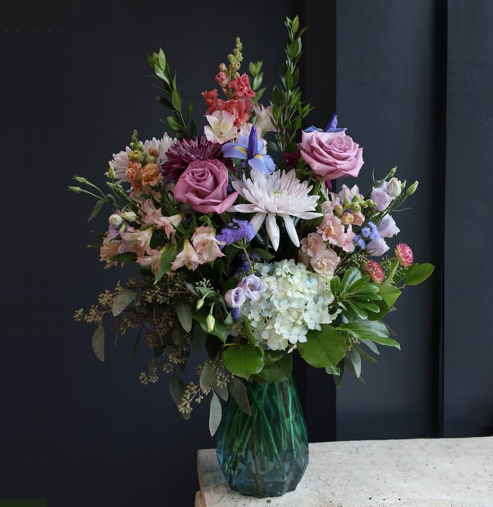 A Gem - A gorgeous glass vase with a gradient of green to blue filled with premium pastel stems! This arrangement is a gem of a find!