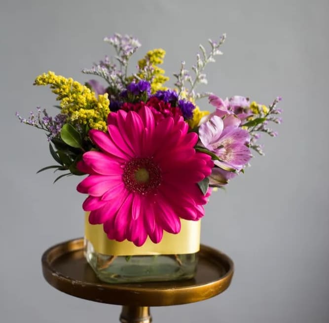 Brighten Your Day - Bright arrangement featuring carnations, gerbers, alstromeria and more in a 4&quot; glass cube which is wrapped in a colorful ribbon. 