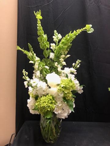 Happy Thoughts Vase - Lots of happy thoughts spew out of this lovely fresh vase arrangement. With bells of Ireland popping out the top and green and white hydrangeas cushioning their fall. This lovely display is sure to show love to anyone who receives its bounty.