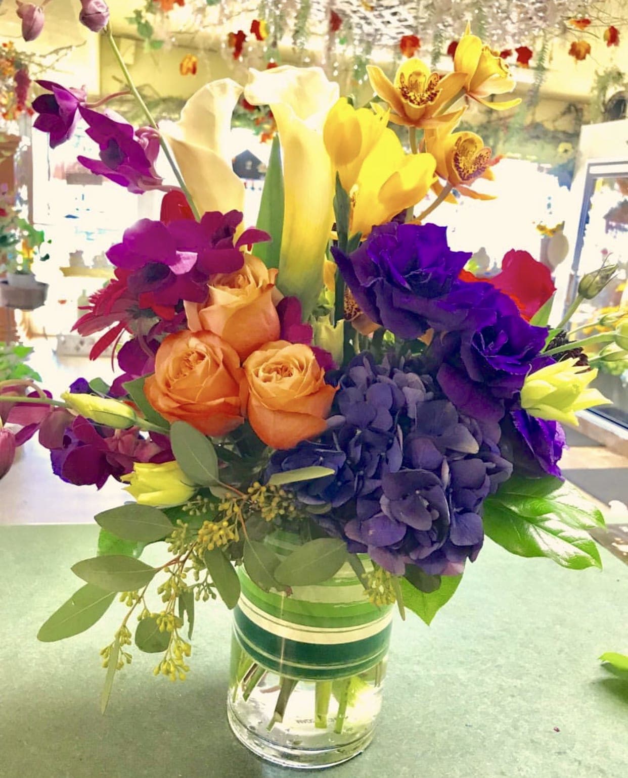 Brighten you up Brighten you up - This beautiful exotic arrangement filled with colorful exotic flowers is a play on textures with a tropical theme. Arrangement flowers may vary depending on availability and season