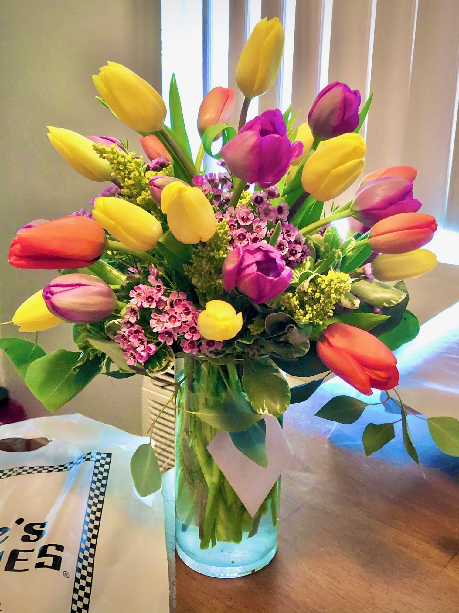Tulips Wild - A colorful mixture of 20 Tulips accented by wax flower in a clear 8&quot; cylinder vase. 