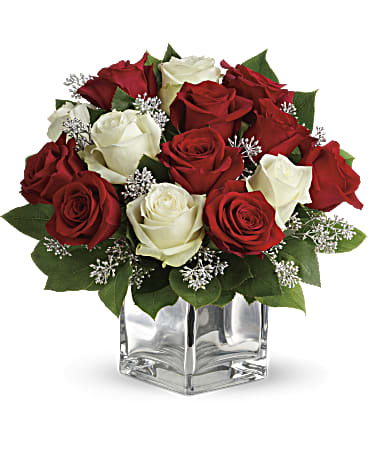 Teleflora's Snowy Night  - Give her a charming look of red and white roses with silver accents. This impressive dozen rose bouquet includes red roses and white roses accented with assorted greenery. Orientation: All-Around