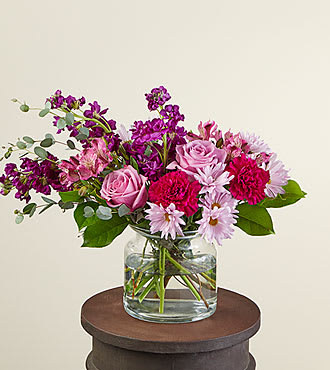 Eckert Florist's FTD Lollipop Bouquet - Send our Lollipop Bouquet an unexpecting friend. Designed with berry hues that will brighten their day and fill their room. These happy stems are paired with beautiful foliage for a stunning aesthetic. *Flower variety and color shades will vary.