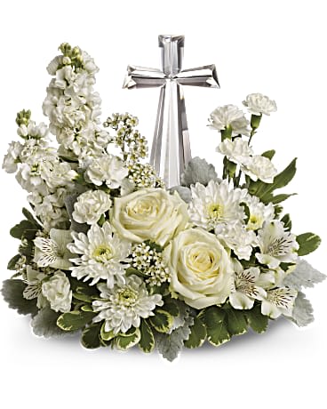 Divine Peace - An elegant display of faith and divine peace, this beautiful arrangement will comfort the bereaved in a truly thoughtful and respectful way. An exquisite crystal cross is surrounded by a bed of lovely blossoms. It is sure to be appreciated and always remembered. A fragrant mix of pure white blooms - including roses, alstroemeria, stock, carnations and waxflower - is accented with dusty miller and variegated pittosporum around an exclusive Crystal Cross keepsake. Orientation: One-Sided  SUBSTITUTION POLICY – Always deliver the freshest flowers! Please note the bouquet pictured reflects our original design.  If the exact flowers or container in this arrangement are not available, our local florists will create a beautiful bouquet with the freshest available flowers.