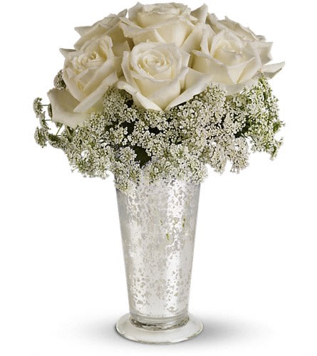 Teleflora's White Lace Centerpiece - Queen Anne's lace forms a delicate collar around radiant white roses inside an antiqued Mercury Glass Vase. Looks lovely next to the wedding guest book on smaller cocktail tables or on your beloved wife's boudoir. White roses and Queen Anne's lace are the simple but gorgeous ingredients in this centerpiece presented in an Mercury Glass Antique Vase.Approximately 9&quot; W x 12&quot; H Orientation: All-Around As Shown : T189-1A