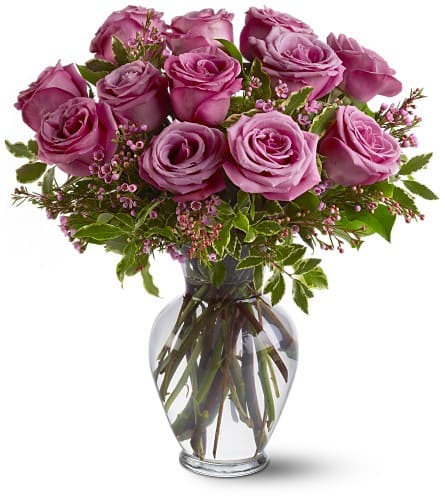 A Dozen Lavender Roses - Adoration and enchantment with a dash of regal majesty - the lavender rose says it all. With tone-on-tone accents this luxurious dozen offers a striking yet softly feminine floral bouquet for any occasion. 12 lavender roses with variegated pittosporum and salal arrive in a classic glass urn vase. Approximately 14&quot; W x 16&quot; H Orientation: All-Around As Shown : TFWEB335