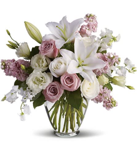 Isn't It Romantic - Tonight will certainly be romantic if you send this classic arrangement today! Beautiful hues and gorgeous blossoms will deliver your love. A stunning arrangement of light pink roses white roses lilies lisianthius and sweet pea plus pink stock make this one of our most desired selections.Approximately 19&quot; W x 17 1/2&quot; H Orientation: One-Sided As Shown : T9-1ADeluxe : T9-1BPremium : T9-1C