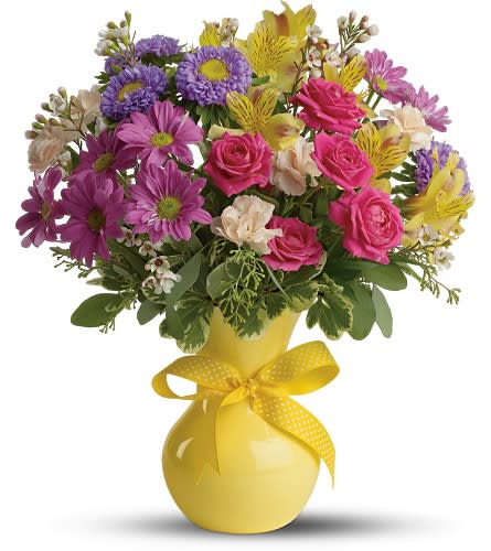 Teleflora's Color It Happy - Whichever season of the year this charming bouquet is like a breath of spring. A gorgeous multicolored bouquet in a yellow vase tied with a yellow ribbon - couldn't be springier! The cheerful bouquet includes yellow alstroemeria purple daisy spray chrysanthemums hot pink spray roses miniature peach carnations white waxflower and purple Matsumoto asters accented with fresh greenery. Delivered in a bright yellow plastic vase tied with a yellow ribbon with white polka dots. Bouquet is approximately 15? W X 17? H. This item is hand-arranged and delivered by a Teleflora florist. Orientation: All-Around As Shown : TFWEB598