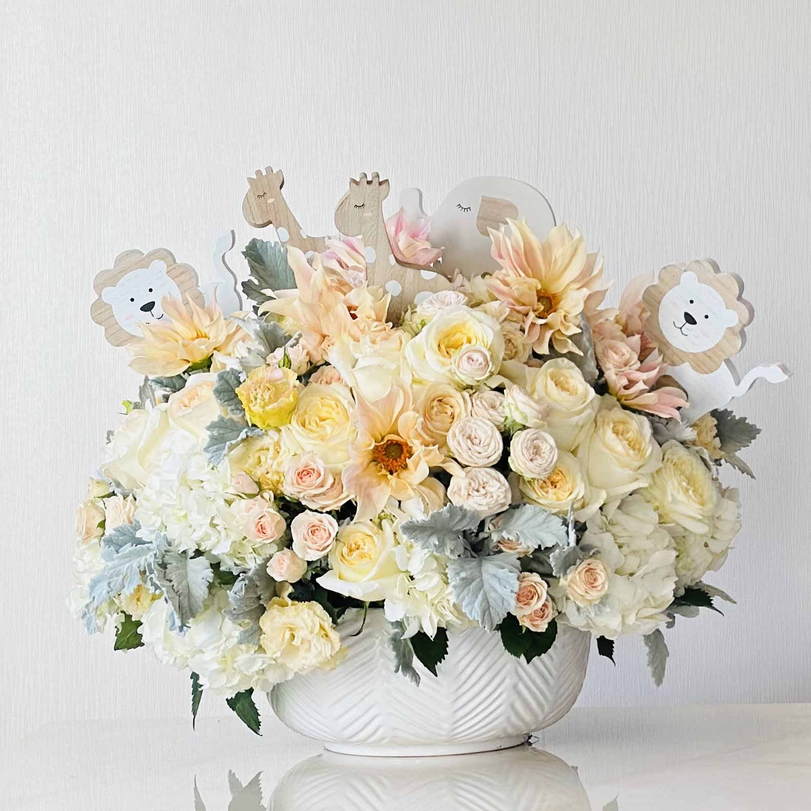 Sweet Baby Sweet Baby - Celebrate a sweet baby’s arrival with this precious flower arrangement. The Sweet Baby joins together a collection of luxury flowers including roses, dahlia, hydrangeas, and spray roses . Designed in a modern white ceramic vase, this arrangement includes beautiful wooden baby animals.