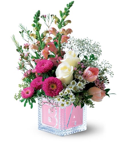 Teleflora's Baby Block (Girl) - When it comes to welcoming a new baby into the world this charming arrangement in a keepsake glass block really coos! Roses snapdragons and tulips arrive in a glass baby block. Available in pink or blue. Indicate preference in the special instructions field at checkout. Approximately 10&quot; W x 13&quot; H California Residents: Prop 65 Warning Orientation: One-Sided As Shown : TF47-2