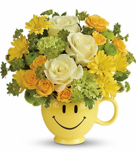 Teleflora's You Make Me Smile Bouquet - Put a smile on their face - and in their heart - with this happy as can be bouquet! Hand-delivered in a food safe mug for years of satisfied sipping this cheerful gift of roses and mums spreads happiness wherever it goes. This cheerful bouquet includes light yellow roses yellow spray roses green carnations green button spray chrysanthemums yellow daisy spray chrysanthemums bupleurum and variegated pittosporum. Delivered in a Be Happy mug. Approximately 11&quot; W x 10 3/4&quot; H Orientation: All-Around As Shown : T600-1ADeluxe : T600-1BPremium : T600-1C