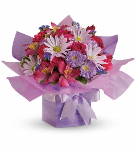 Teleflora's Lovely Lavender Present - This pretty purple present comes with a beautiful surprise - a lovely bouquet of flowers that's perfectly arranged and wrapped to look like a present. The soft lavenders pinks and purples make this a wonderfully feminine gift. Hot pink spray roses and miniature carnations dark pink alstroemeria lavender matsumoto asters daisy spray chrysanthemums statice and pittosporum are perfectly presented here in an exclusive gift box.Approximately 14&quot; W x 11&quot; H Orientation: One-Sided As Shown : T16-2ADeluxe : T16-2BPremium : T16-2C
