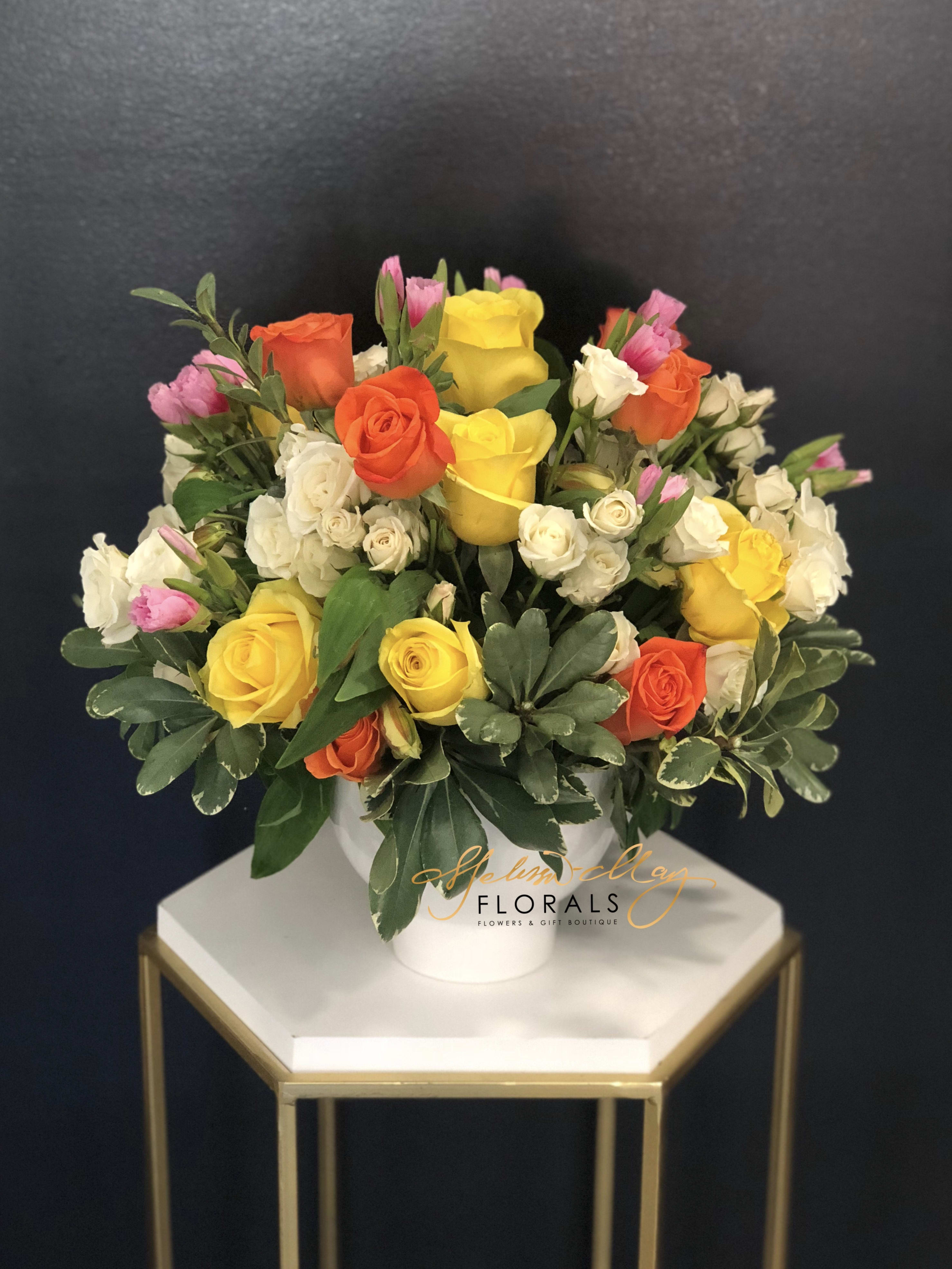 Amazing Grace - A simple arrangement of white lilies and colorful roses, mixed with an assortment of greenery and presented in a ceramic container, can be used to ornament any at-home or business event. An excellent all-purpose selection. Exact container may vary. ( Vase Shown Limited Edition) Picture Shown Deluxe