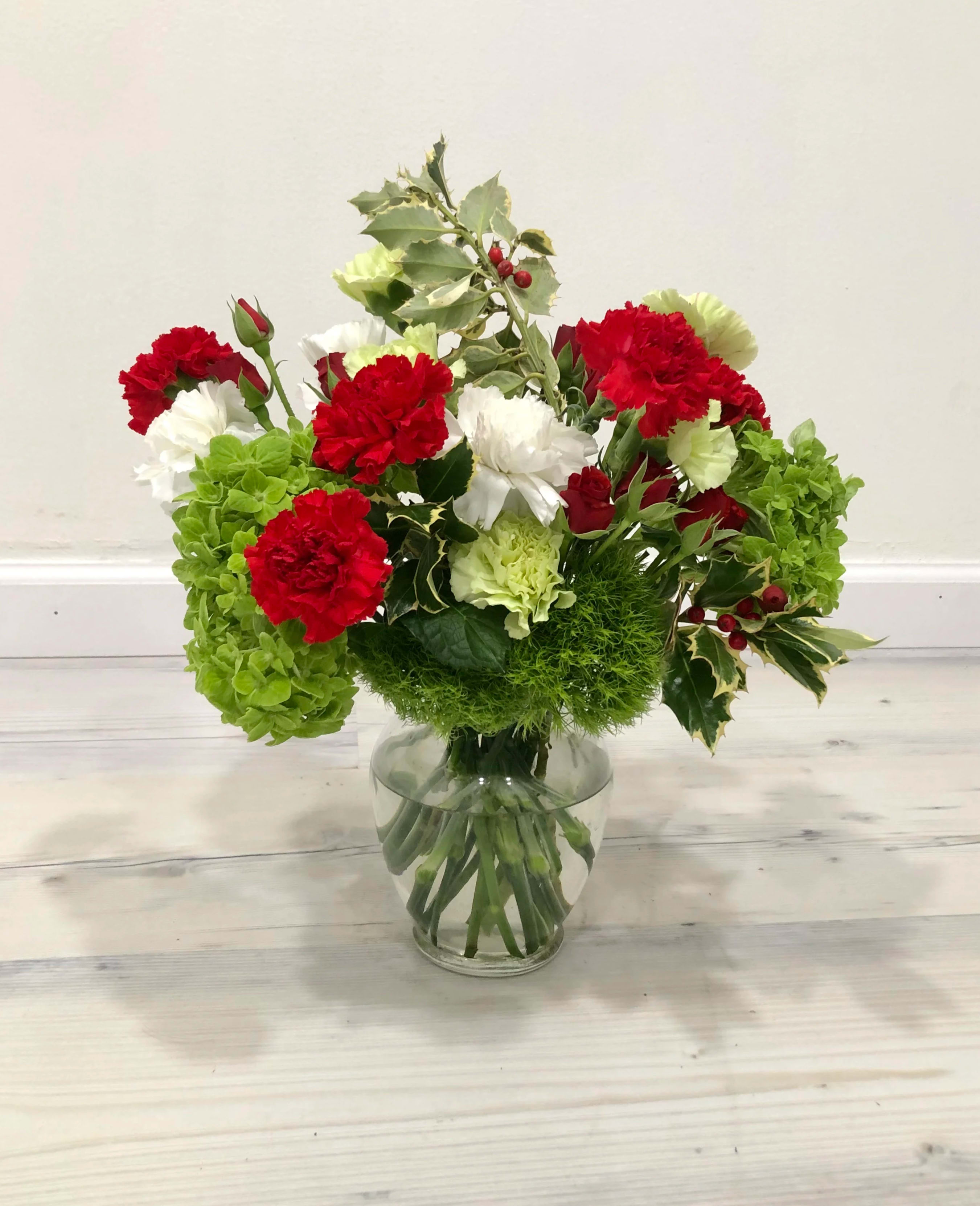 Warm and fuzzy Christmas bouquet in vase Warm and fuzzy Christmas bouquet in vase - Christmas bouquet in a vase with fuzzy green dianthus, spray roses, carnations, and stems of holly.
