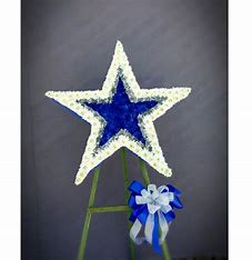 DALLAS COWBOYS STAR DALLAS COWBOYS STAR - BEAUTIFUL TRIBUTE TO THE DALLAS COWBOYS STAR WITH WHITE AND BLUE ON A STANDING ISLE STANDARD SIZE IS 3 FEET ON A 6 FT ISLE STAND CARNATIONS AND POMPOM OTHER SIZES UPON REQUEST