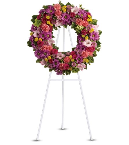 Ringed by Love - The memory of brighter days is always a comfort to those in mourning. This lovely wreath will display your compassion beautifully. A standing wreath of dazzling flowers such as green hydrangea hot pink spray roses pink gladioli and carnations along with a m?lange of multi-colored daisy spray and cushion spray chrysanthemums and greenery is delivered on an easel.Approximately 25&quot; W x 25&quot; H Orientation: One-Sided As Shown : T239-4A