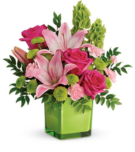 Teleflora's In Love With Lime Bouquet - Lime-a-licious! Fresh shades of green are a great way to contrast pink roses and lilies. Hand-delivered in a lovely leaf green cube it's a loving gift any day of the week! This refreshing arrangement features dark pink roses pink asiatic lilies pink miniature carnations bells of ireland green button spray chrysanthemums and huckleberry. Delivered in a glass cube.Approximately 14&quot; W x 15&quot; H Orientation: One-Sided As Shown : TEV44-1ADeluxe : TEV44-1BPremium : TEV44-1C