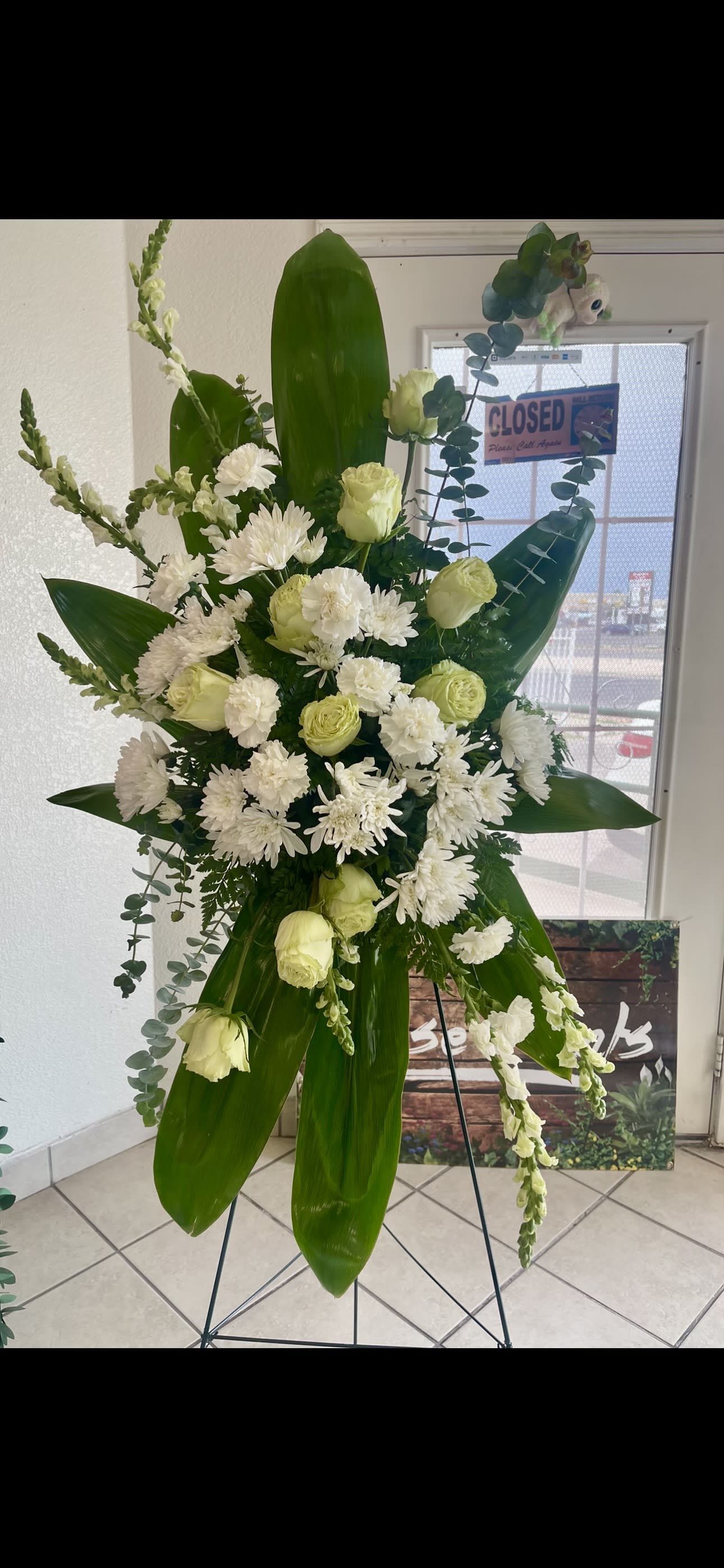 White Sympathy Standing Spray White Sympathy Standing Spray - A very unique and beautiful sympathy arrangement combined in a unique way to accent a different pattern from traditional standing spray arrangements