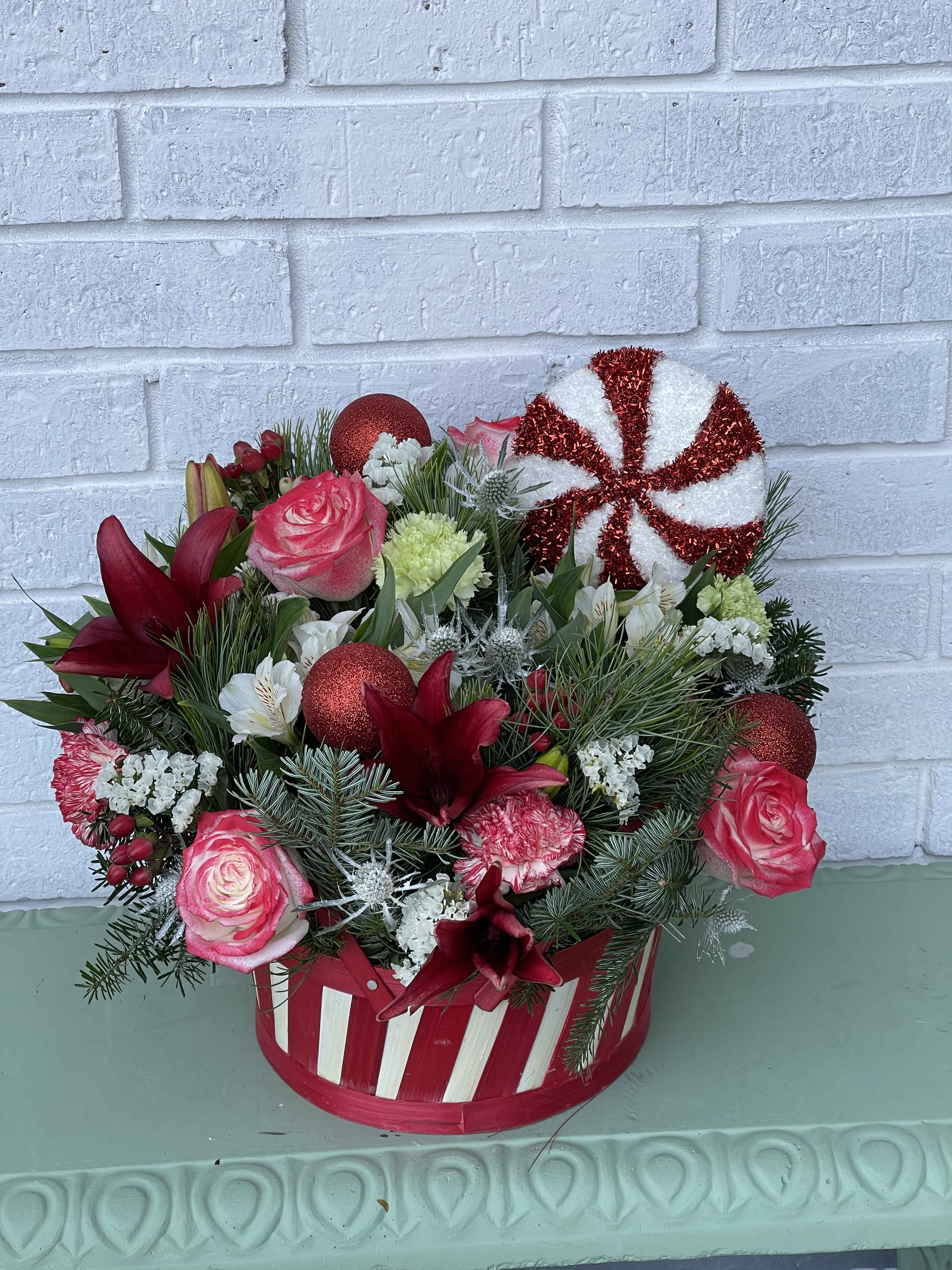 The Jolly Christmas Basket The Jolly Christmas Basket - This beautiful basket has a lot of christmas caracter. We have filled this basket with beautiful greenery, fillers and a variety of christmas flowers. The design is very unique and will be an eye catcher.