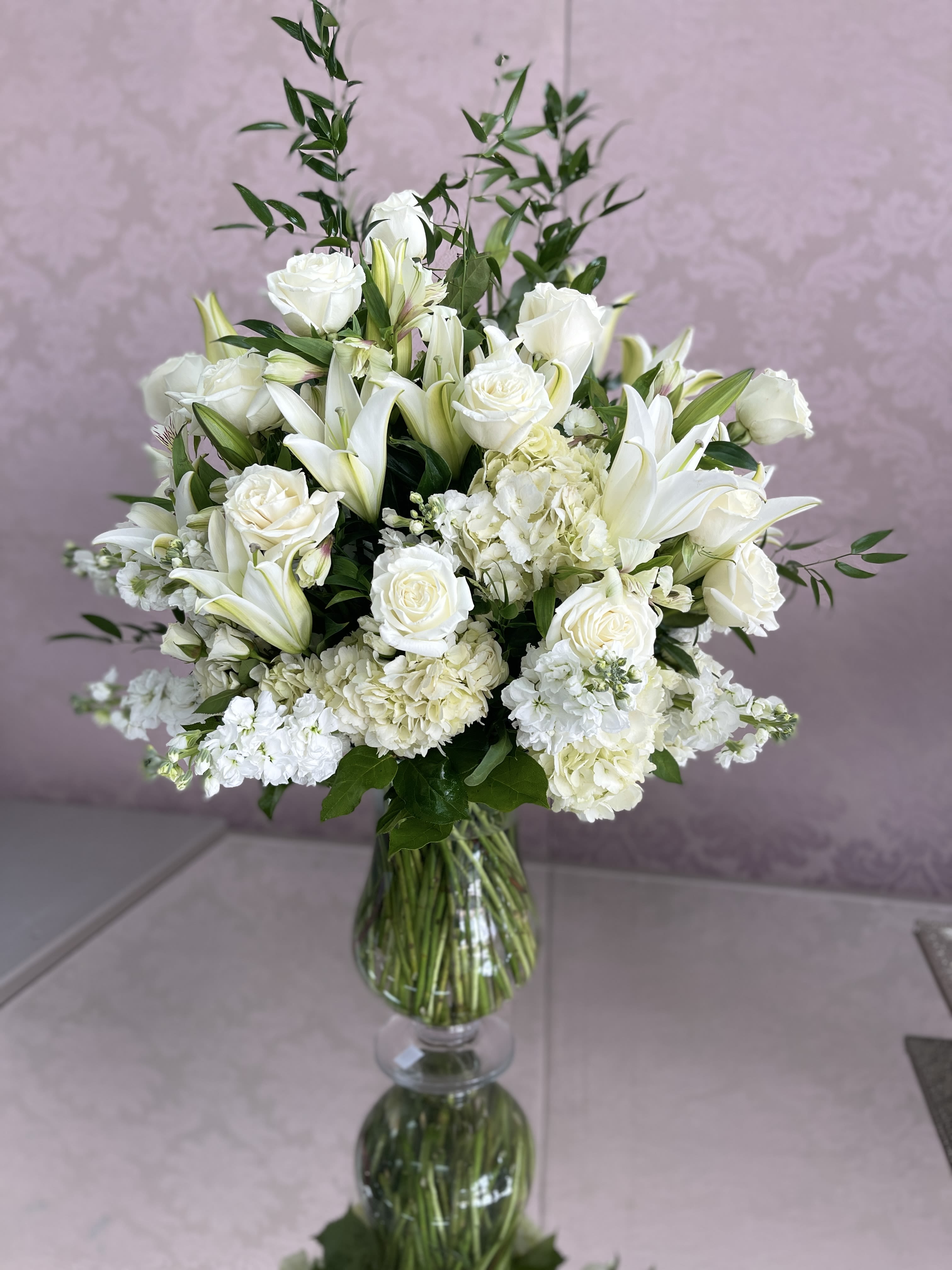 Purest Love Bouquet by Atlanta's Finest Flowers Purest Love Bouquet by Atlanta's Finest Flowers - This Purest Love bouquet includes hydrangea, asiatic lilies, alstroemeria, miniature carnations, stock and fresh green pittosporum. Delivered in clear urn vase
