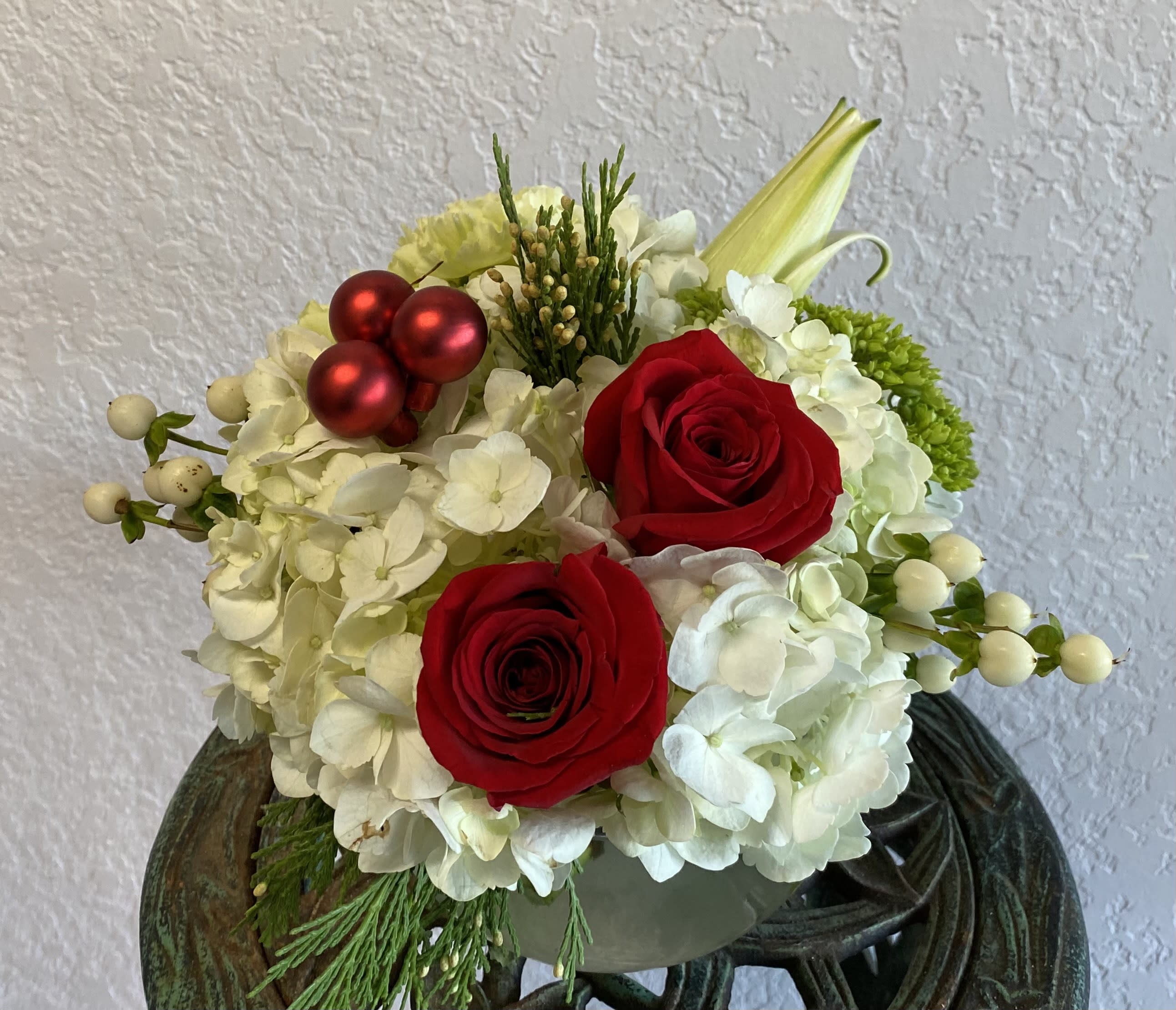 CFH112 - A compact arrangment for the table with flowers such as hydrangeas, roses and holiday accents. 