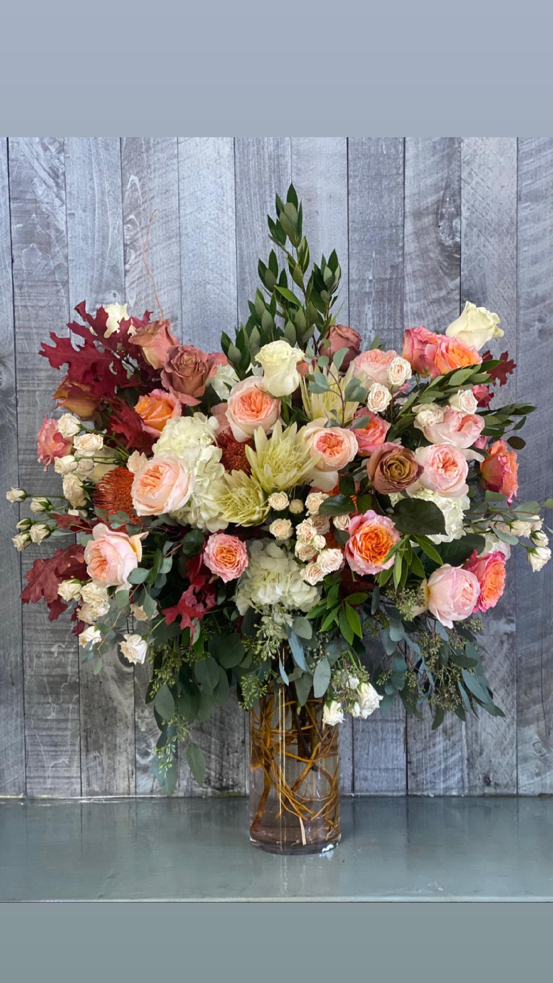 Symphony of color - A tall arrangement with the nicest selection of seasonal flowers
