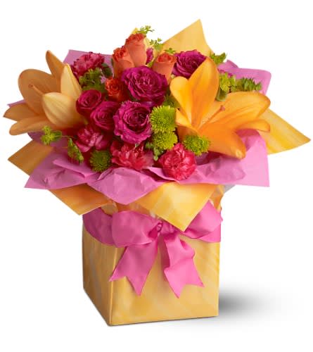 Teleflora's Tres Chic Present Teleflora's Tres Chic Present - Don't just give someone flowers... send them a blooming gift-wrapped present! This splendid floral arrangement of hot pink orange and chartreuse blooms - nestled in tissue paper and all wrapped up in sizzling orange with a hot pink ribbon - is tr?s chic and just right for a party birthday or any fashionable occasion. A mix of fresh flowers such as roses Asiatic lilies and carnations in shades of hot pink orange and green is nestled in tissue paper and delivered in an orange-gift-wrapped glass cube vase that?s adorned with a pink satin ribbon. Approximately 13" (W) x 13" (H) Orientation: One-Sided As Shown : TFWEB306