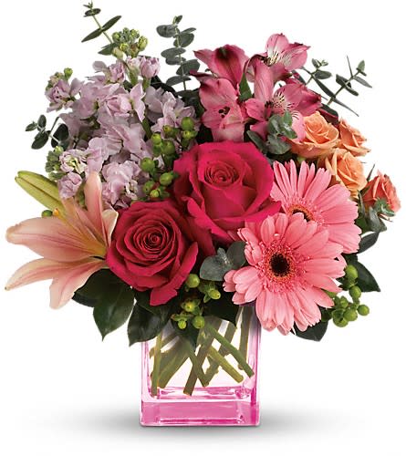 Teleflora's Painterly Pink Bouquet - Pretty as a painter's palette! Warm wondrous shades of pink and peach play perfectly in this feminine bouquet that's artfully arranged in a pretty pink cube vase. What a fun fabulous way to celebrate any occasion! This colorful arrangement includes hot pink roses peach spray roses pink asiatic lilies pink gerberas dark pink alstroemeria pink stock green hypericum spiral eucalyptus and camellia leaves. Delivered in a pink cube vase. Approximately 13&quot; W x 13 1/2&quot; H Orientation: All-Around As Shown : T600-8ADeluxe : T600-8BPremium : T600-8C