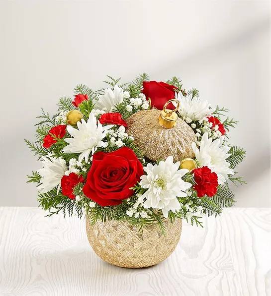 Sparkling Holiday Ornament - The signature beauty of the holiday season is captured in our limited-edition arrangement. Joyful red and white blooms are gathered with festive gold ball ornaments and arranged in our Glittering Gold Holiday Ornament™ container. With its diamond-embossed design, lavish gold glitter and matching lid, it’s a luxurious keepsake they’ll treasure for years to come. Our florists hand-design each arrangement, so colors and varieties may vary due to local availability