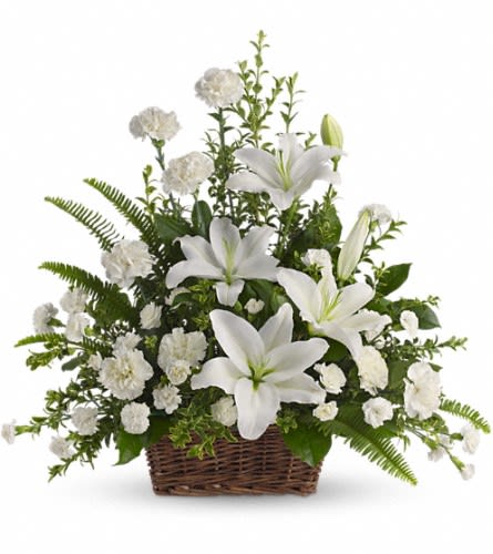 Peaceful White Lilies Basket - Whether you send this beautiful arrangement to the family home or to the service all will appreciate its elegance and grace. The contrast of brilliant white blossoms and dazzling greenery create a wonderfully calm and dignified setting. Gorgeous flowers such as white lilies carnations and miniature carnations mix with vibrant greens in a large basket. Simply stunning.Approximately 26&quot; W x 25&quot; H Orientation: One-Sided As Shown : T228-1A