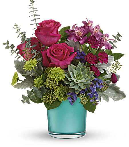 Teleflora's Topaz Wonderland Bouquet - A wondrous splash of color and style to brighten any occasion! Presented in a shimmering blue topaz-colored vase, this vibrant bouquet of pink, green and purple blooms is a study in stylish contrasts. This wondrous arrangement features dark pink roses, dark pink alstroemeria, miniature purple carnations, green button spray chrysanthemums, blue sinuata statice, dusty miller, spiral eucalyptus, seeded eucalyptus, lemon leaf, and a large green echeveria succulent plant. Delivered in a Blue Topaz Polished Gem Cylinder. Approximately 13 1/2&quot; W x 15&quot; H 