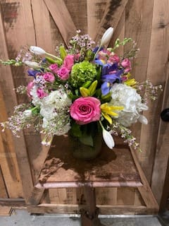 Spring Garden - This arrangement is approximately 20&quot; tall with a variety of spring flowers. Included are Hydrangea, Iris, Roses, Lilies, Tulips Waxflower and assorted greens and fillers. Additional sizes will include more of the featured flowers but be larger. 