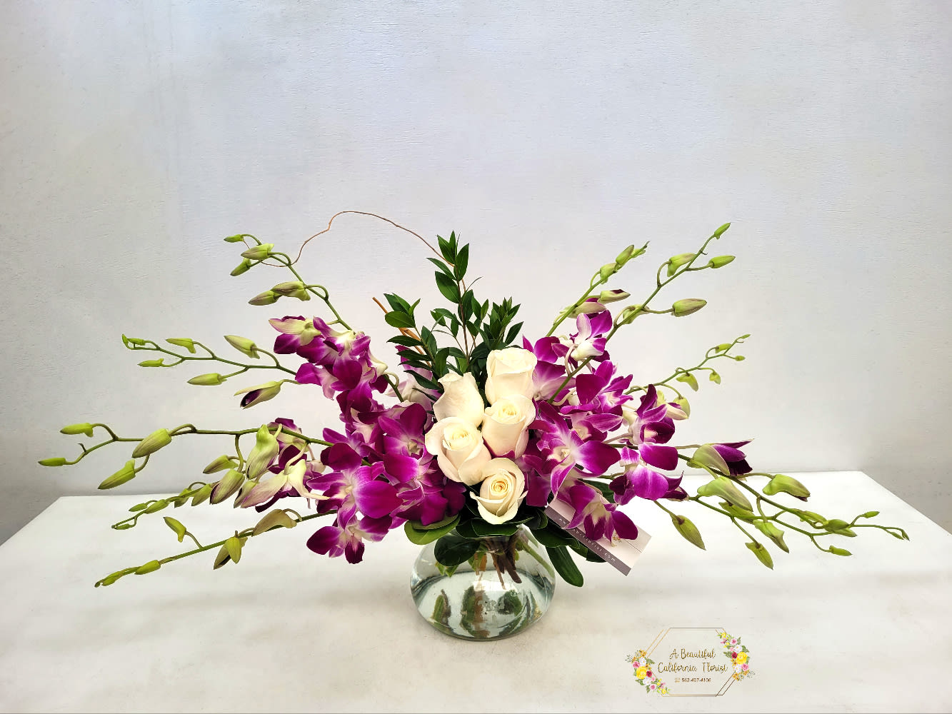Lavender Elegance Lavender Elegance - Lavender Elegance, roses and orchids arranged in a vase.