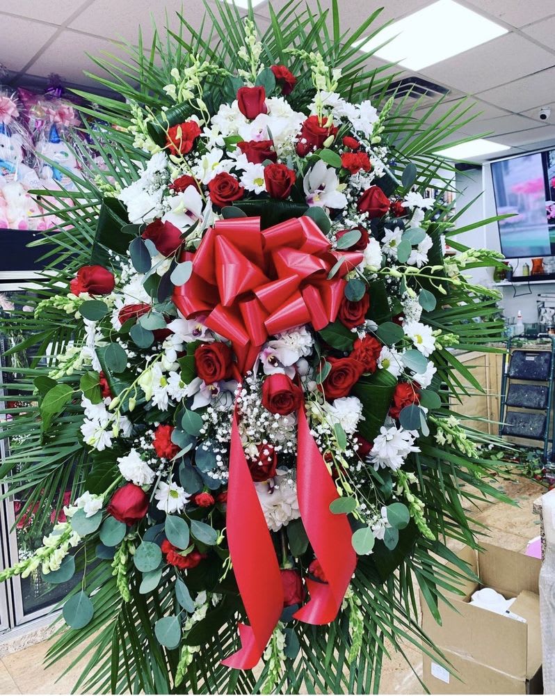 RED AND WHITE FUNERAL SPRAY OF FLOWERS - Send your loved one off with this beautiful spray of flowers, a mix of red roses, white daisies, cymbidium orchids, baby's breath, chrysanthemums, hydrangeas, dendrobium orchids with exotic greenery, with a big red bow, 