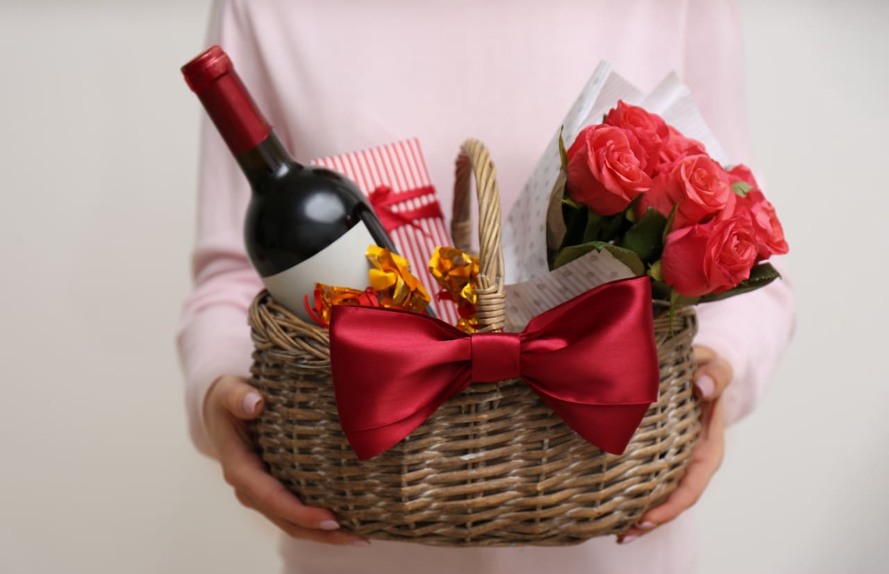 Sip and Bloom: A Perfect Gift Basket - Unveil the art of thoughtful gifting with our exquisite basket. Nestled within are the finest blooms, radiating elegance, and a bottle of fine wine, adding a touch of celebration to the moment. Perfect for expressing warmth and joy, this gift basket combines flowers' beauty with wine's indulgence, creating a truly enchanting and memorable gesture.