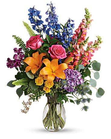 Colors Of The Rainbow Bouquet - Color any occasion beautiful with this lovely bouquet of hydrangea, roses and lilies in all the colors of the rainbow. This colorful bouquet includes purple hydrangea, pink roses, yellow spray roses, orange asiatic lilies, purple alstroemeria, blue delphinium, pink snapdragons, blue eryngium, huckleberry, oregonia, Israeli ruscus, sword fern, silver dollar eucalyptus, seeded eucalyptus, and lemon leaf. Delivered in a jordan vase.
