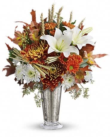 Teleflora's Harvest Splendor Bouquet - Celebrate fall with this stunning mix of warm autumn blooms and crisp white lilies, arranged in a chic mercury glass julep vase. This unique bouquet includes white asiatic lilies, dark orange alstroemeria, white cushion chrysanthemums, rust-colored daisy chrysanthemums, bronze disbud chrysanthemums, seeded eucalyptus, oak leaves and wheat. Delivered in an exclusive silver Mercury Glass large julep vase.