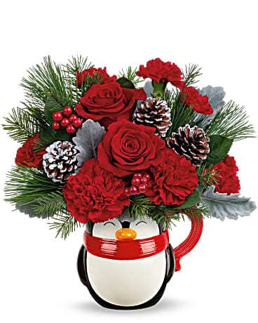 Teleflora's Send A HugÂ® North Pole Penguin - Filled with festive flowers now, hot cocoa later, this sweet ceramic penguin mug is a holly jolly holiday treat! This bouquet features red roses, red carnations, miniature red carnations, dusty miller, douglas fir and white pine. Delivered in a North Pole Penguin Mug.